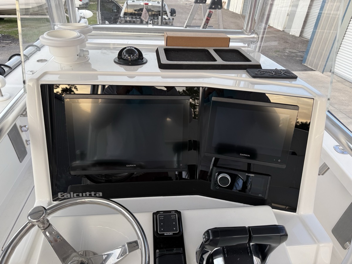 Custom acrylic dash with flush-mounted screens and switch row on a Calcutta center console