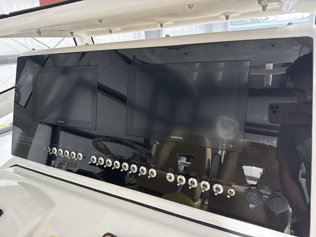 Gloss black custom acrylic dash panel with a row of chrome switches, fabricated by Dynasty Marine Customs